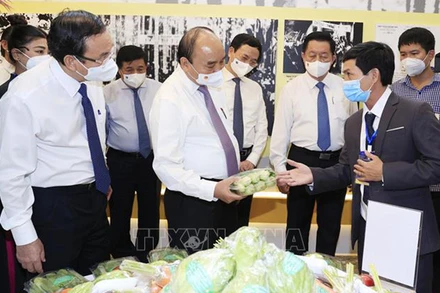 Chủ tịch nước Nguyễn Xuân Phúc thăm khu trưng bày các sản phẩm tiêu biểu của huyện Hóc Môn và Củ Chi. (Ảnh: TTXVN)
