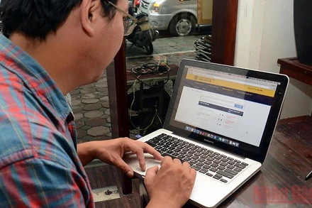 Phụ huynh tìm hiểu, đăng ký thông tin tuyển sinh đầu cấp trực tuyến. (Ảnh: Duy Linh)