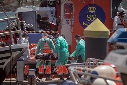  Lực lượng cứu hộ khẩn cấp trợ giúp người di cư sau khi được giải cứu ở ngoài khơi quần đảo Canary, Tây Ban Nha, ngày 26/3/2021. (Ảnh: AFP/TTXVN)