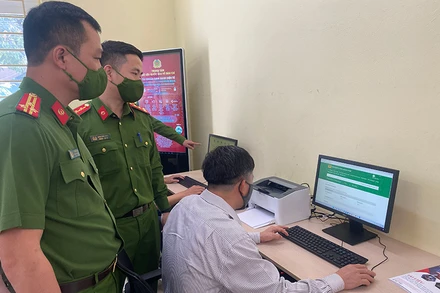 Cán bộ Cục Cảnh sát quản lý hành chính về trật tự xã hội hướng dẫn người dân thực hiện dịch vụ công trực tuyến.