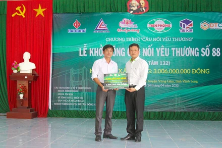 Lãnh đạo Công ty Nhựa Tiền phong trao bảng tượng trưng. (Ảnh: BÁ DŨNG) 