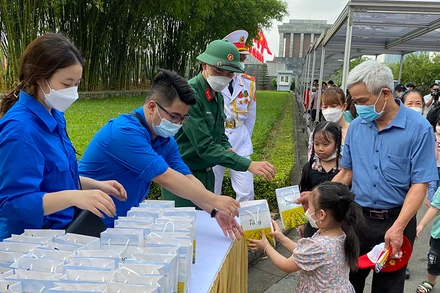 Người dân phấn khởi nhận các phần quà sau khi vào Lăng viếng Bác.