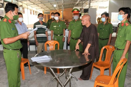 Cơ quan Cảnh sát điều tra thực hiện lệnh bắt tạm giam đối tượng Hồ Hữu Phúc (áo nâu). (Ảnh: Công an TP Sóc Trăng cung cấp)