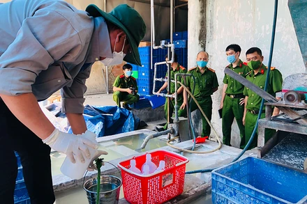 Nhân viên Sở Tài nguyên và Môi trường Đồng Nai lấy mẫu nước thải khu vực để máy nghiền bóng đèn thải.