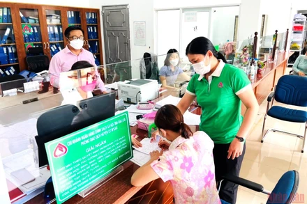 Cán bộ Phòng giao dịch Ngân hàng Chính sách-xã hội huyện Cư M’gar hướng dẫn người lao động làm thủ tục vay vốn ưu đãi theo Nghị quyết 11.