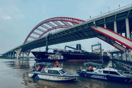 Các lực lượng chức năng khẩn trương giải cứu tàu Outrivaling 3 kẹt dưới gầm cầu Hoàng Văn Thụ.