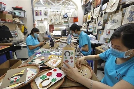 Người khuyết tật sáng tạo các tác phẩm thủ công tại Hợp tác xã Vụn Art ở Hà Đông (Hà Nội). (Ảnh: Minh Quyết/TTXVN)