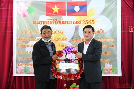 Đồng chí Lê Văn Hường, Tỉnh ủy viên, Bí thư Huyện ủy huyện Nam Giang sang thăm và chúc Tết cán bộ, nhân dân huyện Đắc Chưng, tỉnh Sê Kông, Lào. (Ảnh: THÀNH ĐẠT)