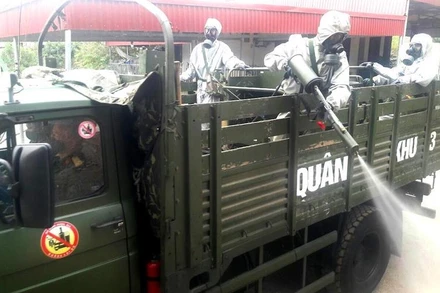 Chiến sĩ lực lượng vũ trang Quân khu 3 phun thuốc tiêu trùng tại xã Hưng Đạo, TP Chí Linh.