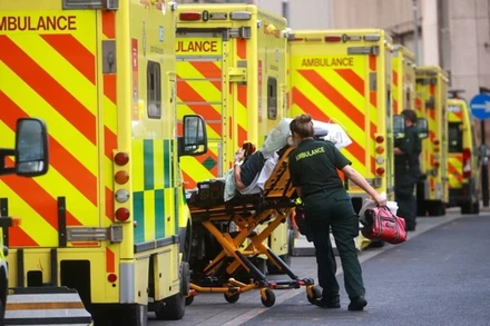 Nhân viên y tế của Anh đưa người bệnh lên xe cứu thương để tới bệnh viện tại London. (Ảnh: Reuters)