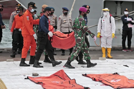 Lực lượng cứu nạn di chuyển túi chứa mảnh vỡ máy bay và phần thi thể người đến cảng Tanjung Priok. (Ảnh: AP)
