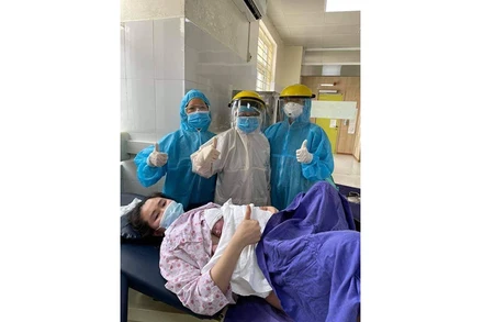 Ê kíp y, bác sĩ của Bệnh viện Sản nhi Quảng Ninh chung niềm vui với sản phụ Nguyễn Thị Hồng L.