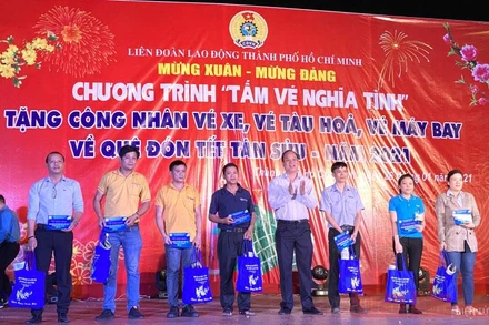 Lãnh đạo TP Hồ Chí Mình và LĐLĐ thành phố trao tấm vé nghĩa tình cho công nhân lao động tối 26-1.