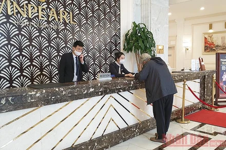 Nhân viên khách sạn hướng dẫn du khách khai Tờ khai y tế theo quy định phòng, chống dịch của Bộ Y tế (Ảnh: TRANG LINH)