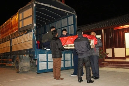 Chuyển hài cốt liệt sĩ quân tình nguyện và chuyên gia Việt Nam lên ô-tô về Việt Nam tại tỉnh Oudomxay, ngày 19-1.