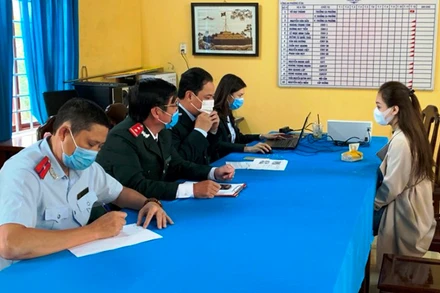 Cơ quan chức năng làm việc với chủ tài khoản mạng xã hội sai phạm (bên phải).