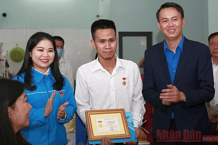 Bí thư Thành đoàn Hà Nội Chu Hồng Minh (bên trái trong ảnh) thừa ủy quyền của Ban Thường vụ T.Ư Đoàn trao Huy hiệu “Tuổi trẻ dũng cảm” tặng đoàn viên Nguyễn Ngọc Mạnh.