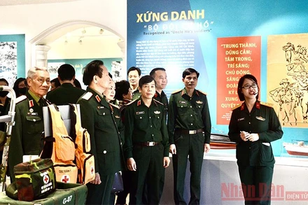 Các đại biểu và khách tham quan nghe thuyết minh tại triển lãm.