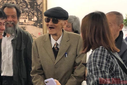 Họa sĩ Chu Mạnh Chấn trong vòng vây bạn bè và người xem triển lãm.