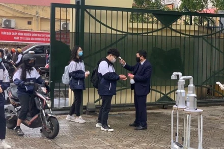 Kiểm tra thân nhiệt cho học sinh vào sáng ngày 2-3 tại Trường THPT Nguyễn Gia Thiều (Long Biên, Hà Nội)