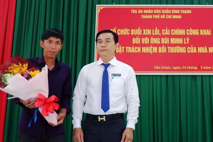 Phó Chánh án TAND quận Bình Thạnh (TP Hồ Chí Minh) Vũ Ngọc Hoan tặng hoa cho anh Lý.