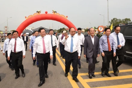 Thủ tướng Chính phủ Nguyễn Xuân Phúc cùng đại biểu các bộ, ngành, địa phương di chuyển trên cầu Cửa Hội. 