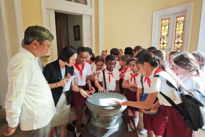 Các em học sinh thích thú khám phá mô hình Trống Đồng-biểu tượng của văn hóa Việt Nam. (Ảnh: Đại sứ quán Việt Nam tại Cuba)
