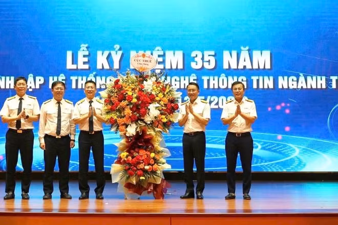 Phó Cục trưởng Mai Sơn và Phó Cục trưởng Lê Long tặng hoa chúc mừng.
