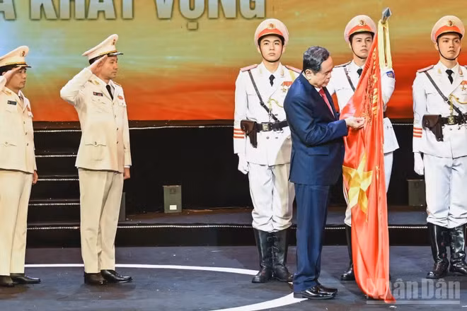 Chủ tịch Quốc hội Trần Thanh Mẫn gắn Huân chương Hồ Chí Minh lên lá cờ truyền thống của lực lượng Cảnh sát kinh tế. (Ảnh: DUY LINH)