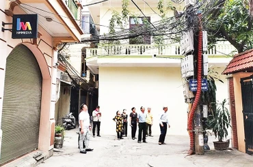 Cán bộ, người dân phường Nghĩa Đô, quận Cầu Giấy giám sát việc lắp đặt camera an ninh trên địa bàn phường. 