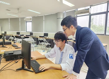 Học sinh Lê Trọng Khôi và thầy giáo trong giờ Tin học.
