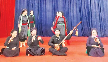 Bà Nguyễn Thị San (ngoài cùng bên trái) và bà Hoàng Thị Huyền (ngoài cùng bên phải) biểu diễn hát then. (Ảnh NGỌC THANH) 