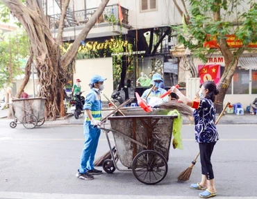 Công nhân Công ty Môi trường đô thị Hà Nội thường xuyên dọn vệ sinh các tuyến đường. (Ảnh PHẠM HÒA)