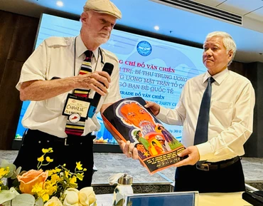 Ông Charles Leslie Clements tặng bức tranh vẽ về Chủ tịch Hồ Chí Minh cho đồng chí Đỗ Văn Chiến.