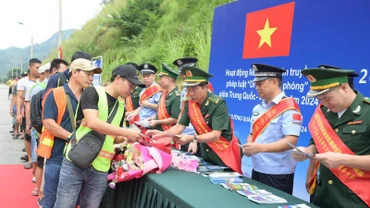Cán bộ, chiến sĩ Đồn Biên phòng Tân Thanh, huyện Văn Lãng, Lạng Sơn (Việt Nam) và lực lượng chức năng Trạm Kiểm tra Biên phòng Pò Chài, Quảng Tây (Trung Quốc), phối hợp phát tờ rơi tuyên truyền pháp luật cho người dân qua lại biên giới. 