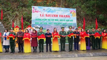 Cán bộ, chiến sĩ Đồn Biên phòng Na Hình, Văn Lãng, (Lạng Sơn), cùng các nhà tài trợ tham gia cắt băng khánh thành đường kiểm tra mốc bảo vệ biên giới. 