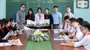 Đại diện Văn phòng Báo Nhân Dân tại Lạng Sơn trao ấn phẩm đặc biệt" Cột cờ Hà Nội" cho giáo viên và học sinh trường Trung học sơ sở thị trấn Bắc Sơn, huyện Bắc Sơn (Lạng Sơn).