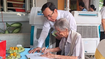 Nhạc sĩ Lư Nhất Vũ ký tặng sách cho đồng chí Bí thư Thành ủy Thành phố Hồ Chí Minh Nguyễn Văn Nên. (Ảnh Trịnh Bình).
