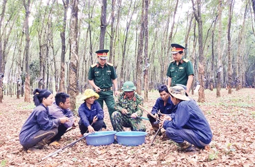 Anh Kpuih Sinh (hàng ngồi thứ tư từ trái sang), trao đổi kỹ thuật cạo mủ cao-su với công nhân.