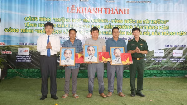 Lãnh đạo Ban Chỉ huy Bộ đội Biên phòng tỉnh Sơn La và xã Yên Sơn tặng ảnh Bác Hồ và cờ Tổ quốc cho các bản.
