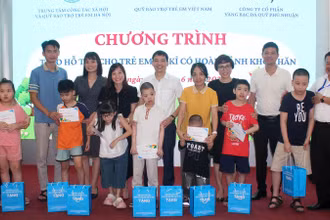Các đại biểu trao hỗ trợ cho trẻ tự kỷ có hoàn cảnh khó khăn tại Hà Nội. (Ảnh NFVC)