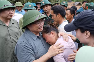 Thủ tướng chia sẻ với nỗi đau mất người thân của người dân vùng lũ quét. (Ảnh TTXVN)