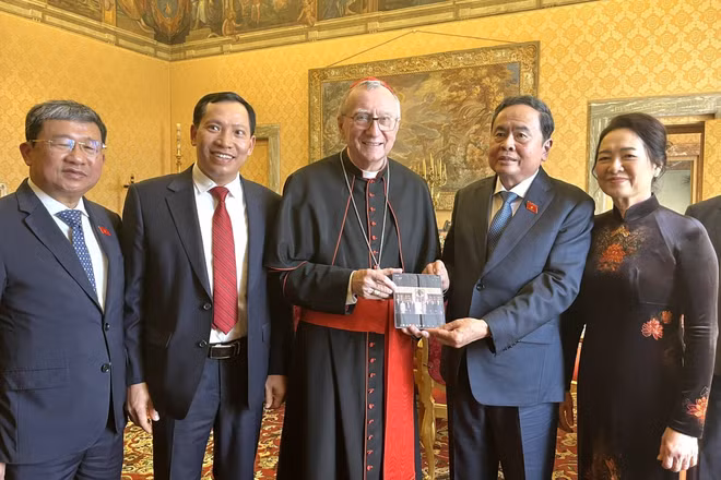 Chủ tịch Quốc hội Trần Thanh Mẫn và Phu nhân chụp ảnh chung với Thủ tướng Tòa thánh Vatican, Hồng y Pietro Parolin và trao đổi tặng phẩm. (Ảnh: TTXVN)