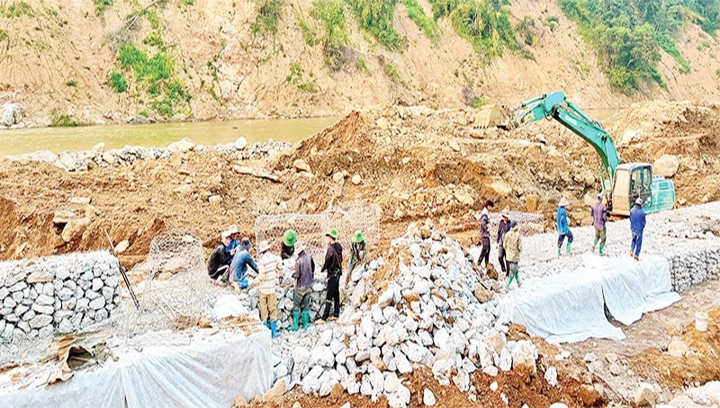 Công nhân Công ty cổ phần đường bộ 2 tập trung khắc phục Quốc lộ 12, đoạn Km 261+900 (Pá Vạt-Mường Luân) bị lũ cuốn mất toàn bộ mặt đường.