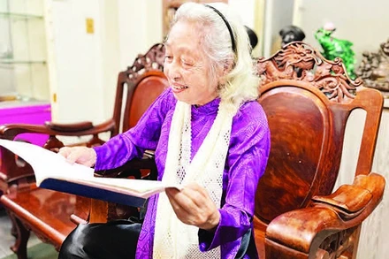 Bà Hoàng Thị Thanh xem lại những tư liệu xưa. (Ảnh: MẠNH HẢO)