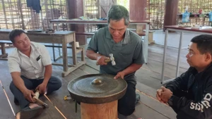 Các nghệ nhân học thực hành chỉnh âm cồng chiêng theo phương pháp của nhà nghiên cứu Bùi Trọng Hiền.