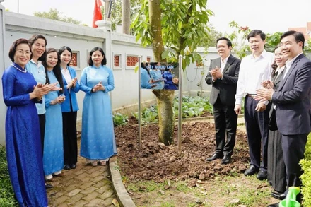 Các đại biểu tham gia trồng cây trong khuôn viên Nhà lưu niệm Lực lượng Nữ du kích Hoàng Ngân.