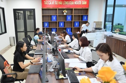 Cán bộ phường Đống Đa, Hà Nội tiếp nhận, giải quyết hồ sơ thủ tục hành chính. (Ảnh nhandan.vn)