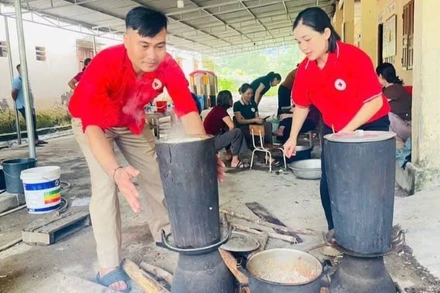 Các tình nguyện viên Chữ thập đỏ tham gia nấu cơm hỗ trợ các hộ sơ tán tại Nghệ An. 