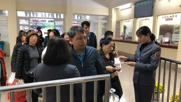 Nhân viên khách vận kiểm soát vé khách vào ga đi tàu.